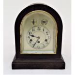 A German mahogany cased mantel clock, with silvered arched dial, striking on gongs. Height 34cm.