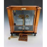 A laboratory balance, by Oertling, model No 101, in a glazed case, with two cased sets of weights,