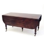 A Regency mahogany and ebony inlaid concertina extending twin flap dining table, standing on five