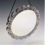 A Middle Eastern ornate lobed silver coloured metal mounted mirror, diameter 18cm