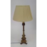A gilt painted wood table lamp with tripod base, with shade. Overall height of lamp 65cm.