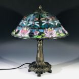 A large Tiffany design twin bulb table lamp, the shade decorated with dragonflies and water