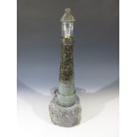 A Cornish serpentine table lamp, modelled as a lighthouse on a rocky base Height 50.5cm.