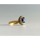 A gold sapphire and diamond oval cluster ring.Condition report: This 18ct gold ring is size K the