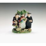 An early 19th century Staffordshire 'Tithe Pig' figure group of traditional form depicting a