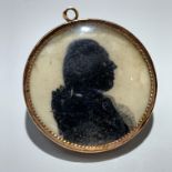 An 18th century gold mounted silhouette pendant, to one side a fashionable gentleman, to the back
