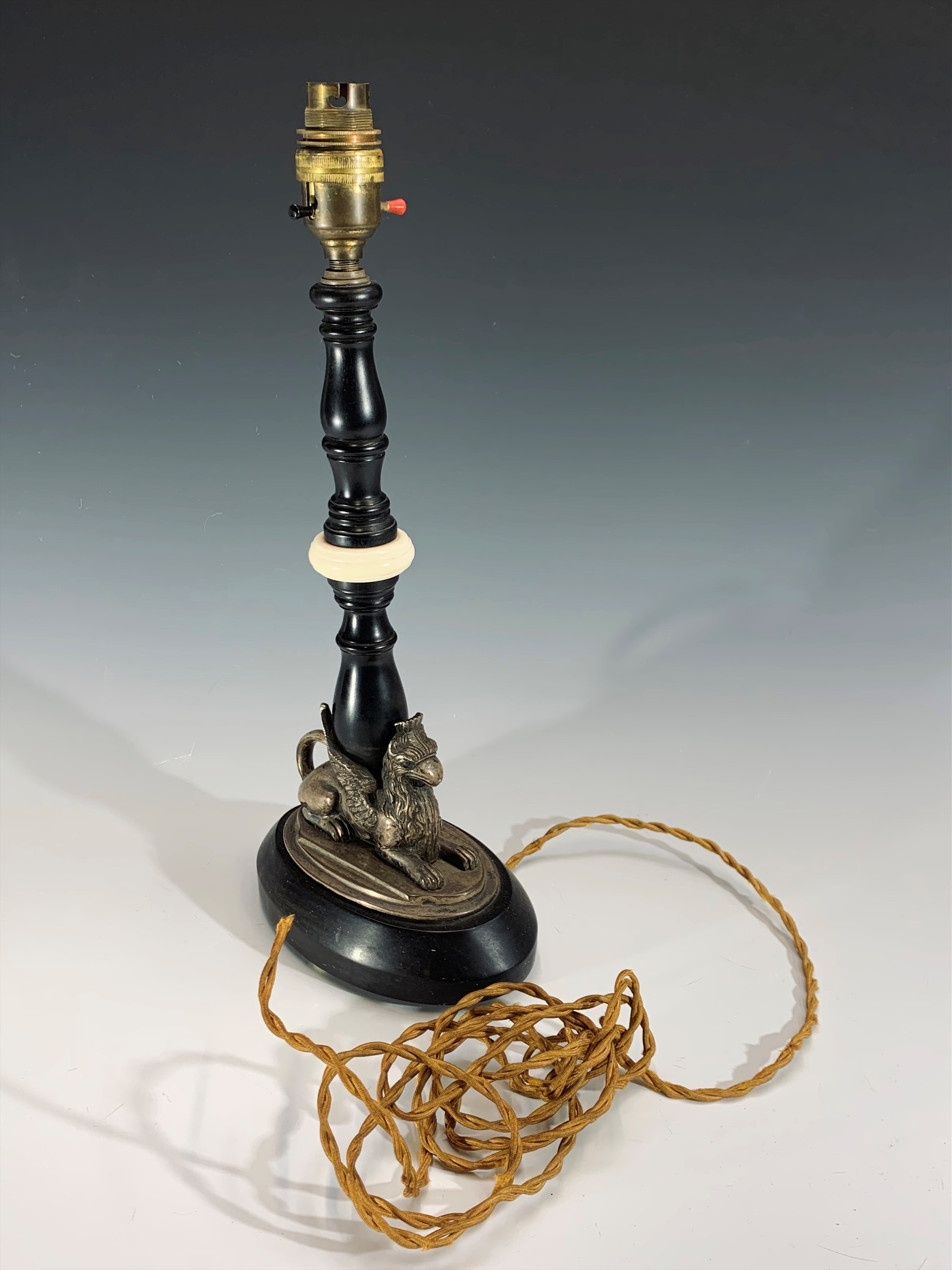 An early 20th century ebonised wood and ivory table lamp, the plated base in the form of a recumbent - Image 3 of 3