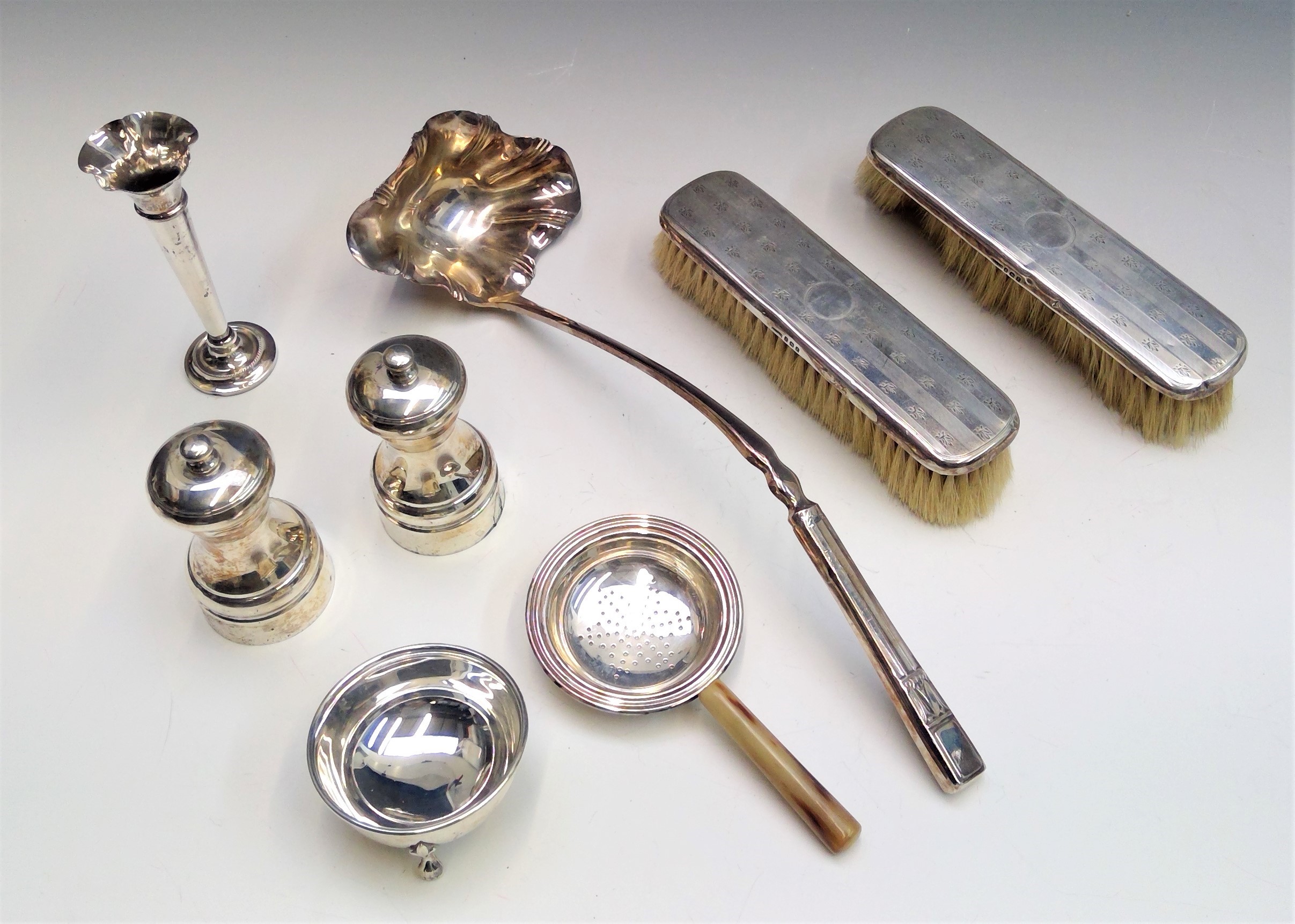 A pair of modern silver pepper mills, a silver spill and two silver mounted brushes together with