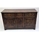 An oak dresser. early 18th century style, with three fielded panel drawers above two doors and a