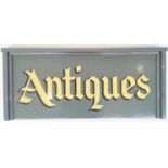 A sign written wooden advertising sign 'Antiques'. 35cm x 81cm x 6cm. (Dimensions: Height 36cm x
