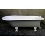 A late Victorian cast iron roll top bath on Grecian column feet, with twin scallop shell soap wells,