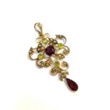 A 9ct gold pendant set peridot, red stone and half pearlsCondition report: No losses no repairs no