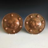 A pair of Arts and Crafts period art copper chargers of circular form, one decorated with