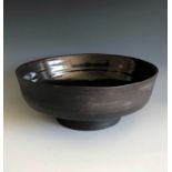 A large black clay Janet Leach bowl, the inside of the bowl is tenmoku glazed, diameter 26cm, height