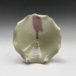 A footed pottery celadon glazed bowl, with scalloped rim, height 8.5cm, diameter 20cm.Condition