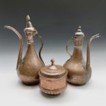 Two Islamic copper ewers, 19th century, heights 42.5cm and 37cm and a copper jar and cover, height