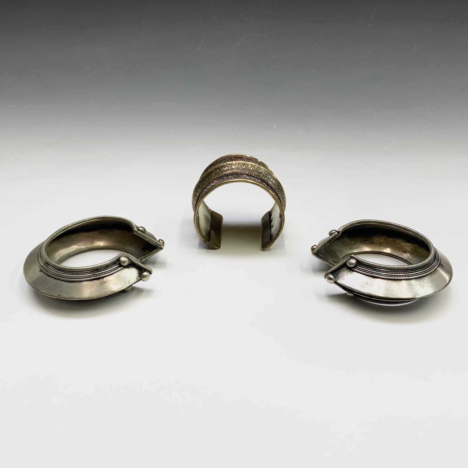 Two silver tribal bangles and a brass cuff, Laos.Condition report: the inner size of all three - Image 7 of 8