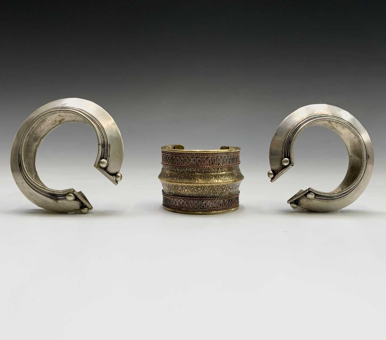 Two silver tribal bangles and a brass cuff, Laos.Condition report: the inner size of all three