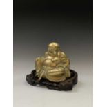 A Chinese brass model of a seated buddha, early 20th century, on a carved wood stand, total height