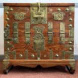 A Chinese elm chest, late 18th/early 19th century, the hinged front with numerous brass mounts