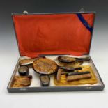 A Chinese faux tortoiseshell dressing table set, early 20th century, gilt decorated with stylised