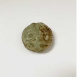A Chinese jade carving, decorated with a seated buddha to the centre, diameter 5.5cm.