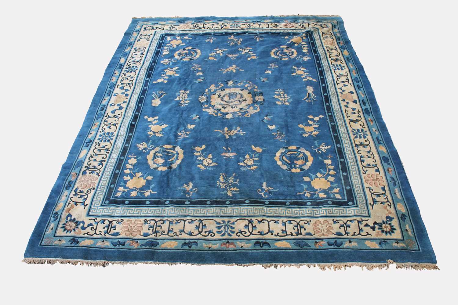 A Chinese Peking carpet, the indigo field with a central circular medallion enclosing a dragon,