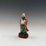 A Chinese porcelain figure of an immortal, Republic period, height15cm, on a wooden stand with