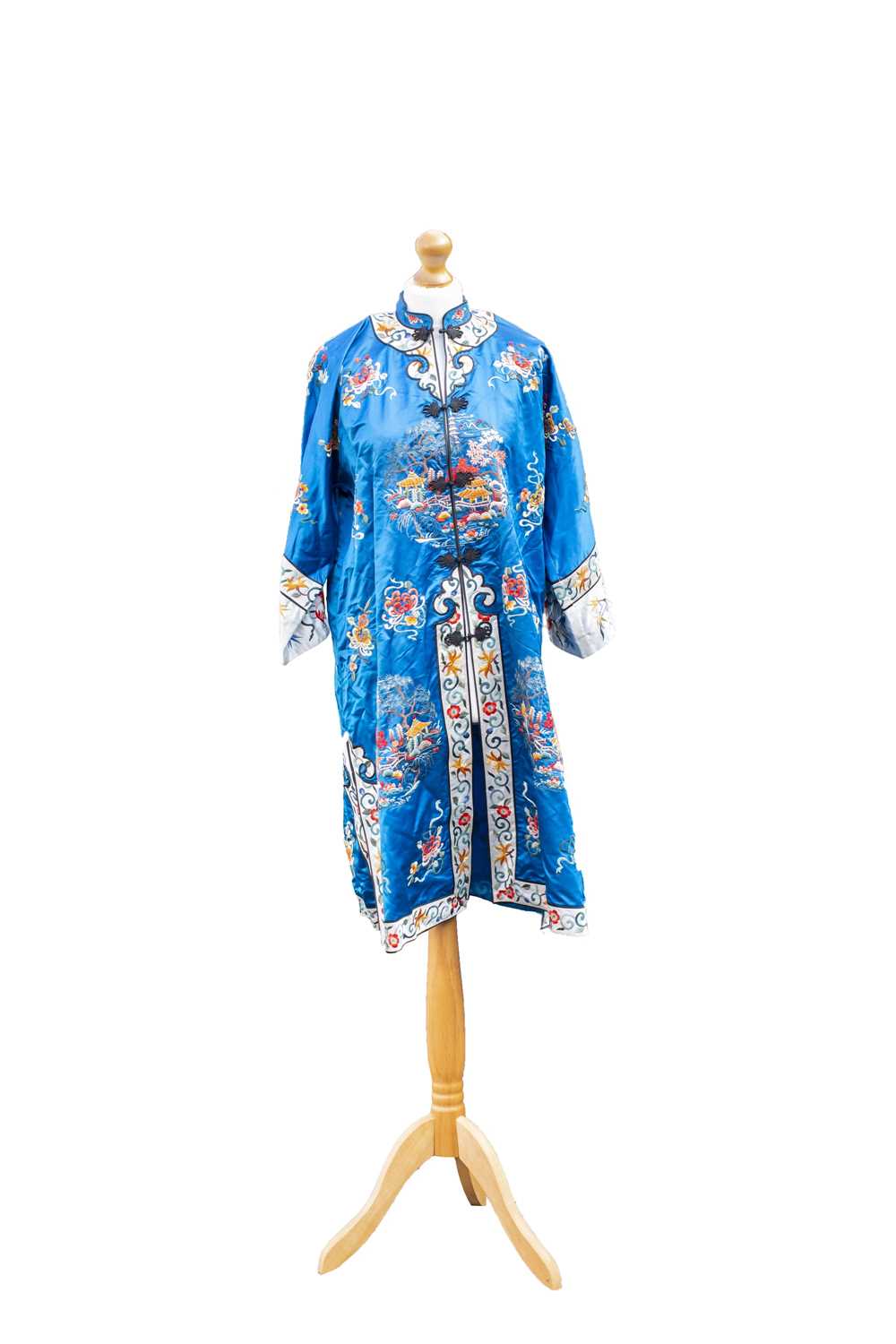 A Chinese blue silk embroidered robe, early 20th century, with floral sprays, pagodas and trees,