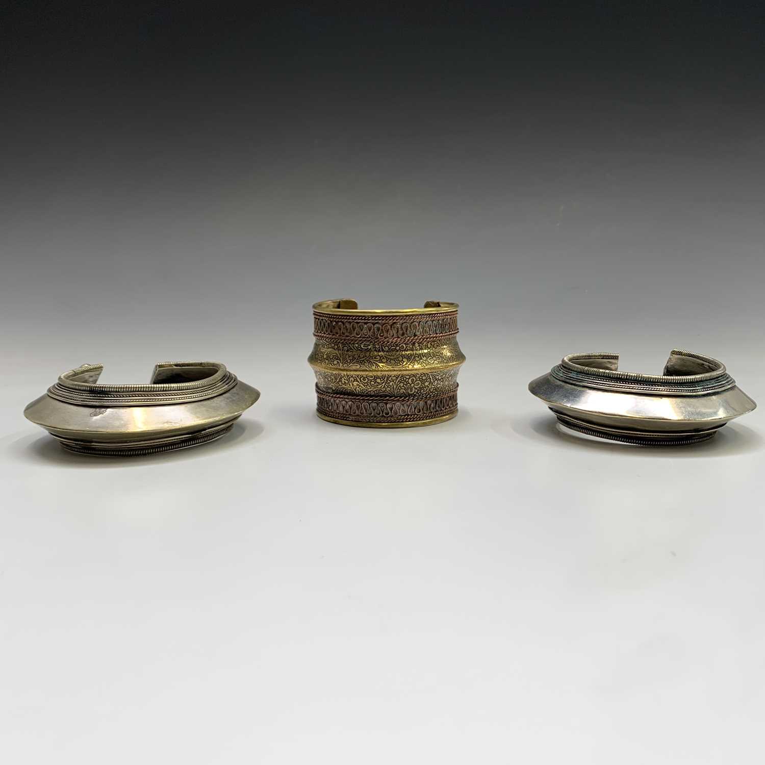 Two silver tribal bangles and a brass cuff, Laos.Condition report: the inner size of all three - Image 8 of 8