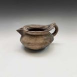 An unusual Middle Eastern earthenware jug, 19th century or earlier, height 14cm, width 26cm.