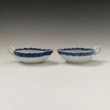 A near pair of Chinese export blue and white sauce boats, Qianlong Period, the interiors each with a