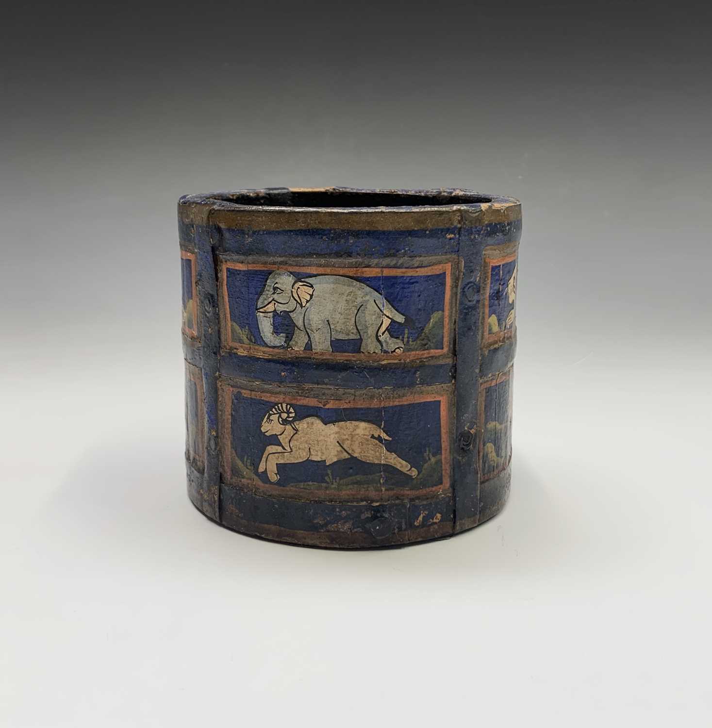 An Indian blue painted wood circular pot, the rectangular panels enclosing stylised animals,