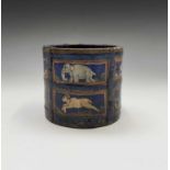 An Indian blue painted wood circular pot, the rectangular panels enclosing stylised animals,