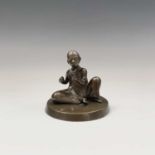 A Japanese bronze figure of a seated boy, circa 1920, on a circular plinth base, height 14cm,