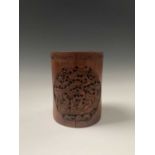 A Chinese bamboo brush pot, 19th century, with rows of calligraphy, carved with trees and pagodas