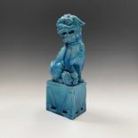 A large Chinese turquoise porcelain dog of fo, 19th century, seated on a plinth, height 38cm.