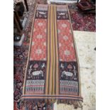 A warp Ikat cotton weaving, Sumatra, Indonesia, decorated with a figure holding an umbrella and a