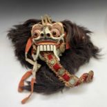 An Asian painted carved wood mask, with hair, mask size 30 x 21cm.
