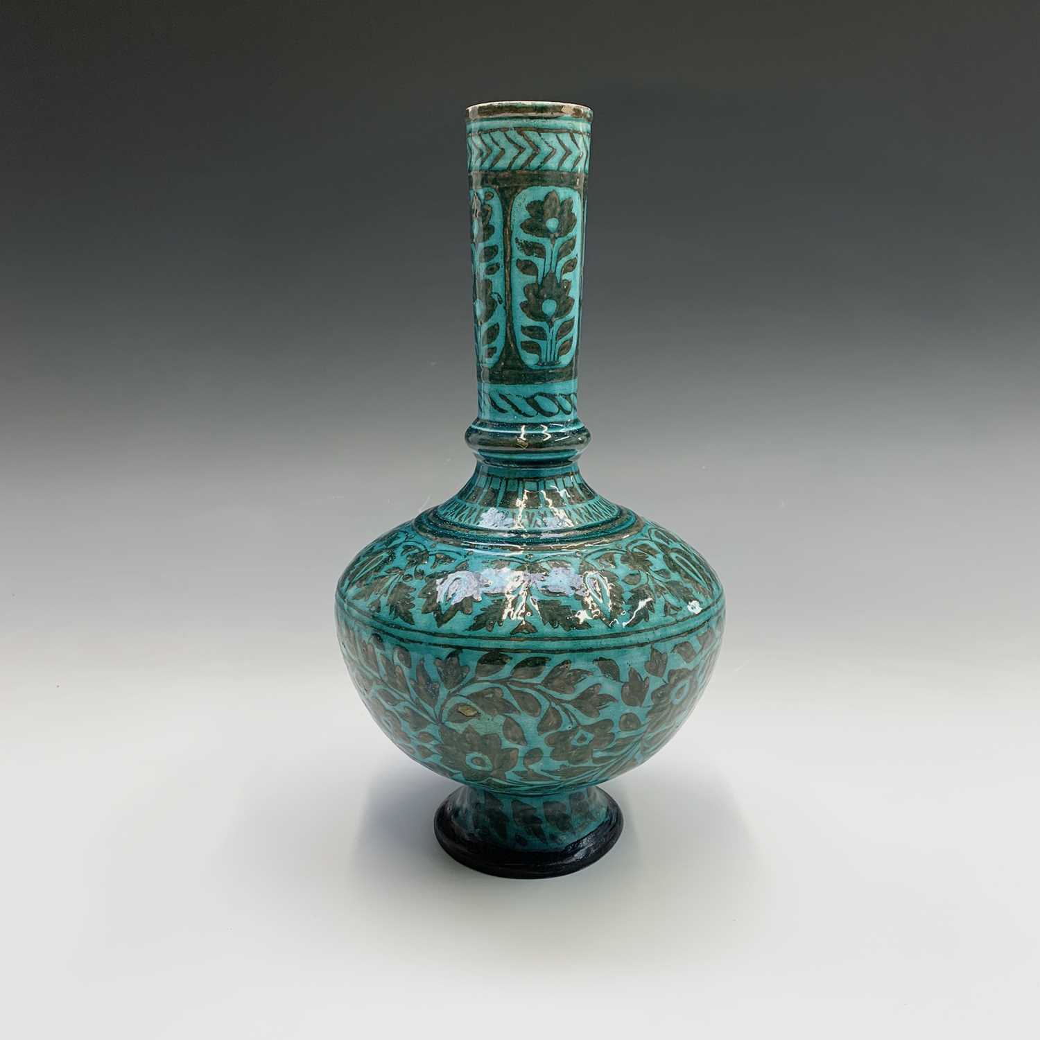 A Persian pottery bottle vase, the turquoise ground with scrolling leafy vines and flowerheads,