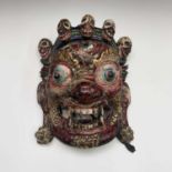 A Bhutanese ceremonial painted carved wood mask, 35 x 29cm.