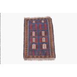 An Afghan Belouch rug, the indigo field with rows of polychrome motifs within a camel hooked gul