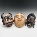 A Thai carved wood mask, a Balinese wood mask and an Indian papier mache mask, largest size 32 x