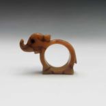 An amber napkin ring in the form of an elephant, width 7.5cm.