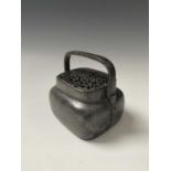 A Chinese bronze hand warmer, 18th/19th century, with swing handle and pierced cover, height 7cm,