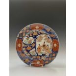 A Japanese Imari charger, late 19th century, with three Geisha girls, trees and flowers, the