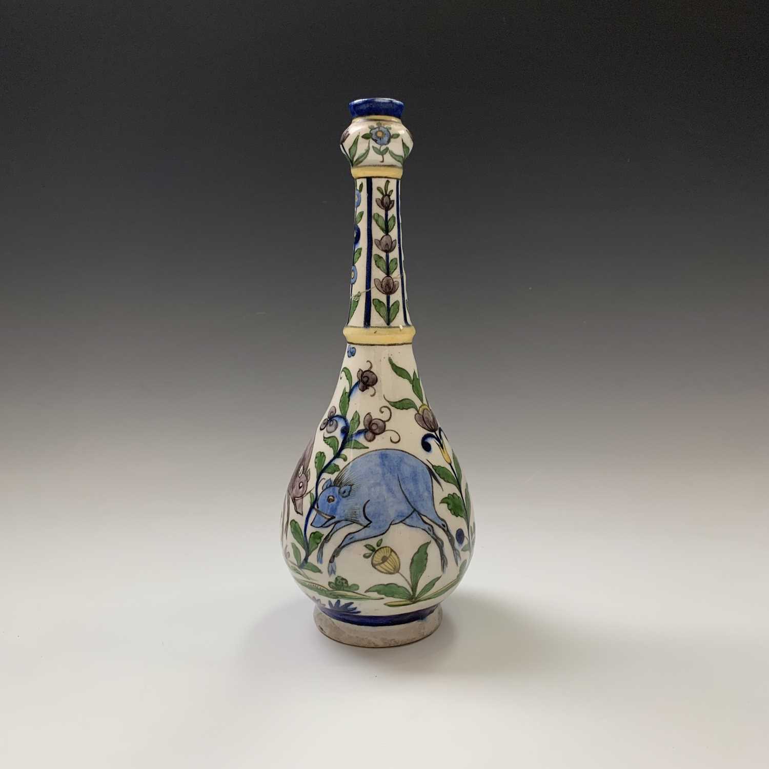 A Persian pottery bottle vase, circa 1900, the white ground with wild boar amongst stylised