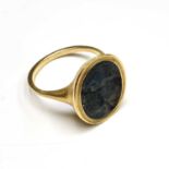 A carved sapphire intaglio heraldic seal carved with conjoined shields set in a gold ring with the