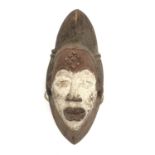 An African carved wood mask, painted in red and white. Height 35cm.