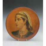 A Watcombe Torquay terracotta wall plaque, painted with a portrait of a woman, impressed mark to